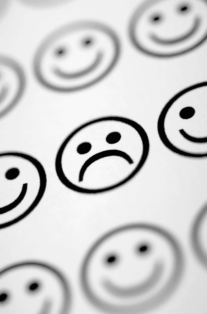 Rosto triste em destaque entre rostos sorridentes